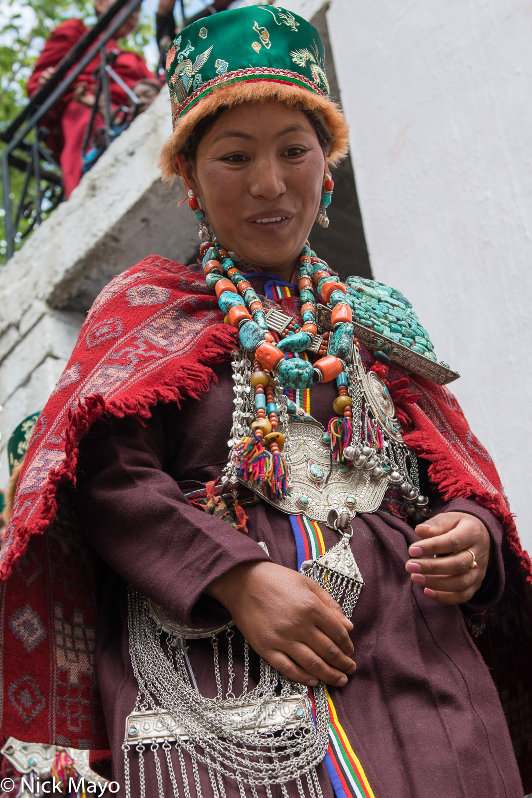 A lady from Kibber at the Ki festival dressed in traditional clothes including a hat, earrings, necklace and breastpiece.