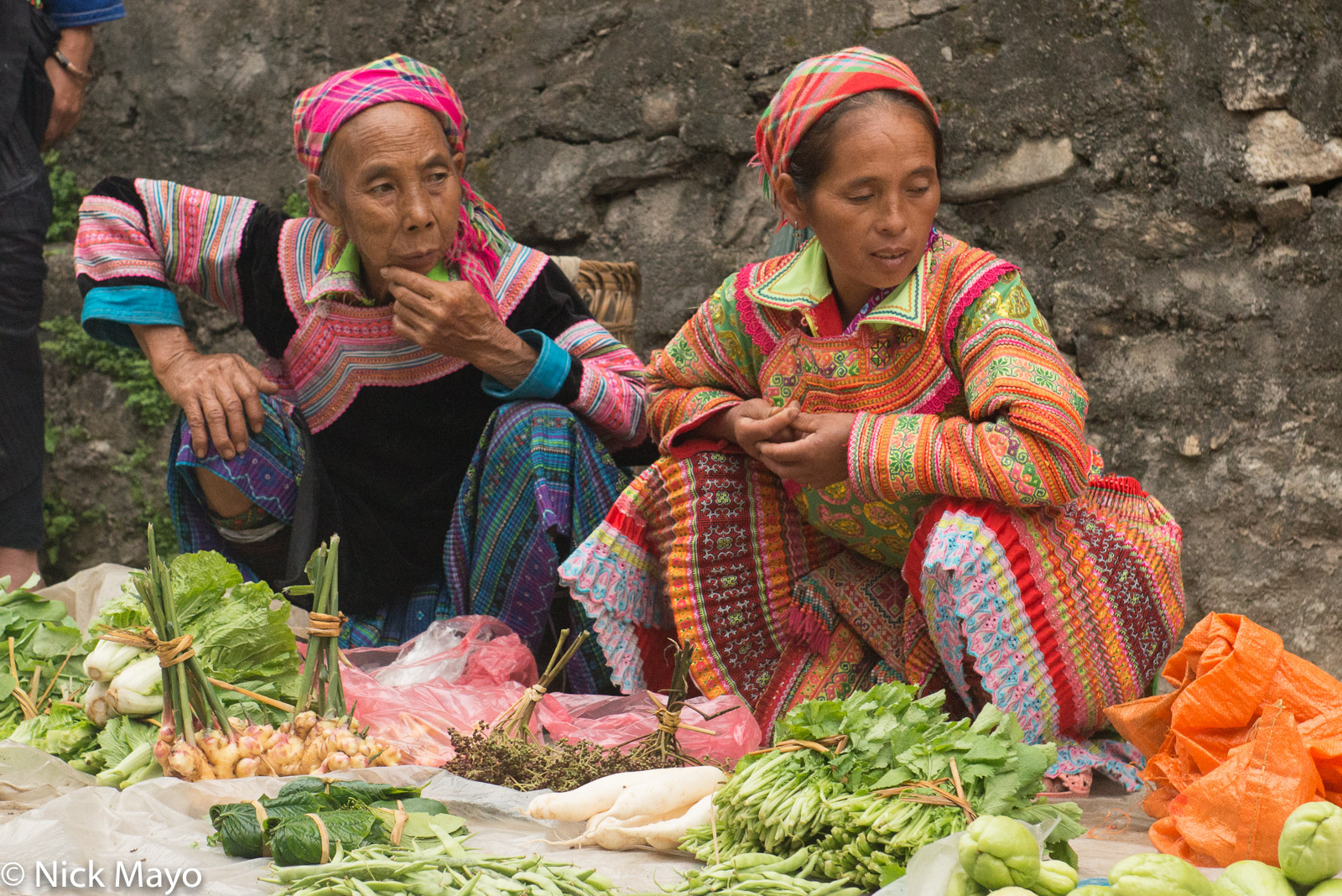 Two Flowery Hmong woman selling vegetables at Su Phi market.