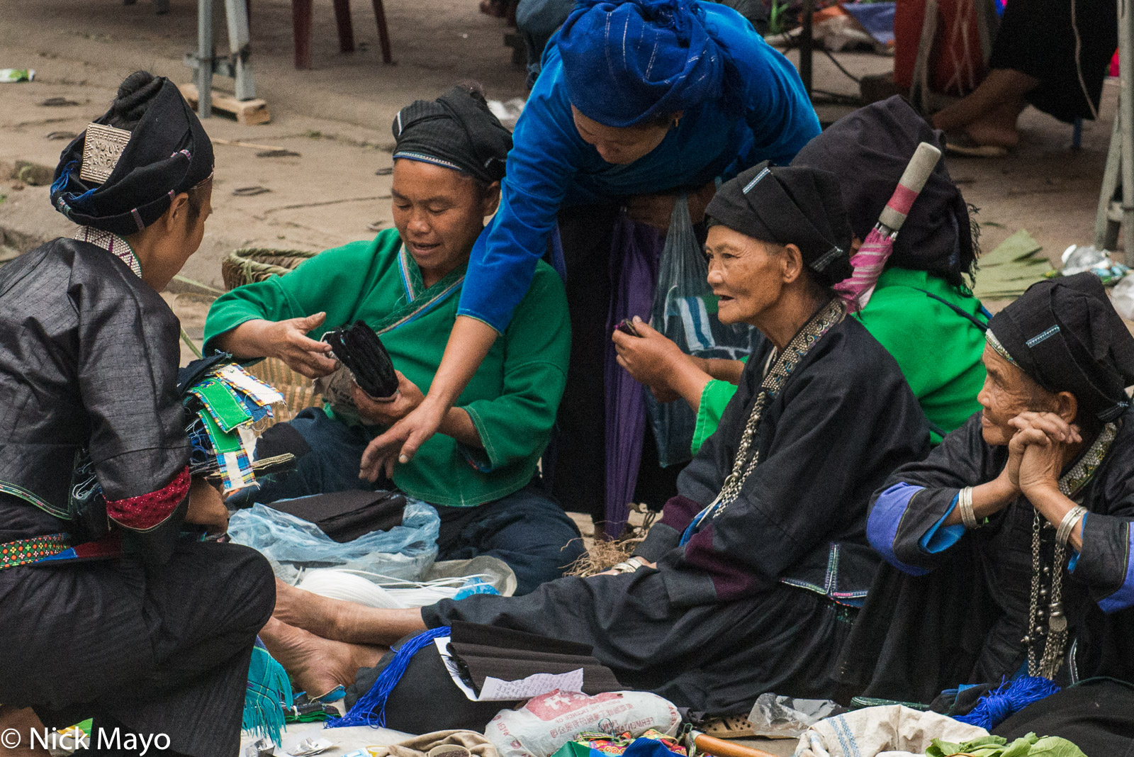 Nung and Tay (Zhuang) women, traditionally dressed and wearing headscarves, necklaces and bracelets, at Su Phi market.