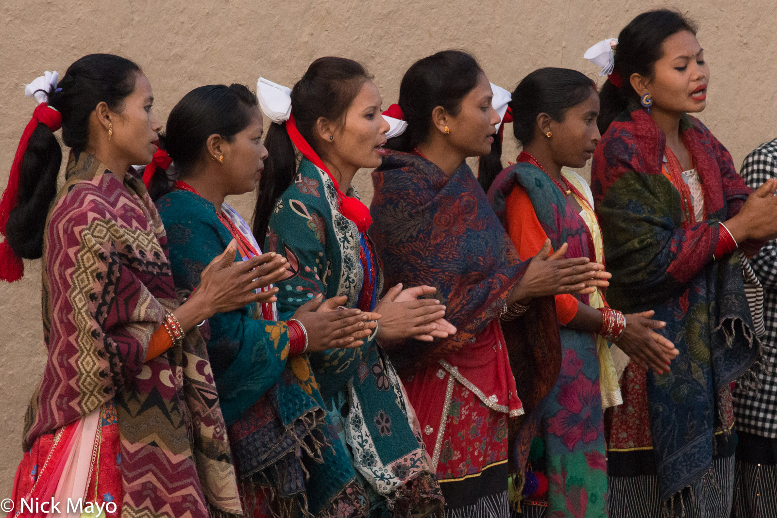 Dangaura Tharu women, wearing hair pieces of red & white, singing during the Maghi festival at Barda.