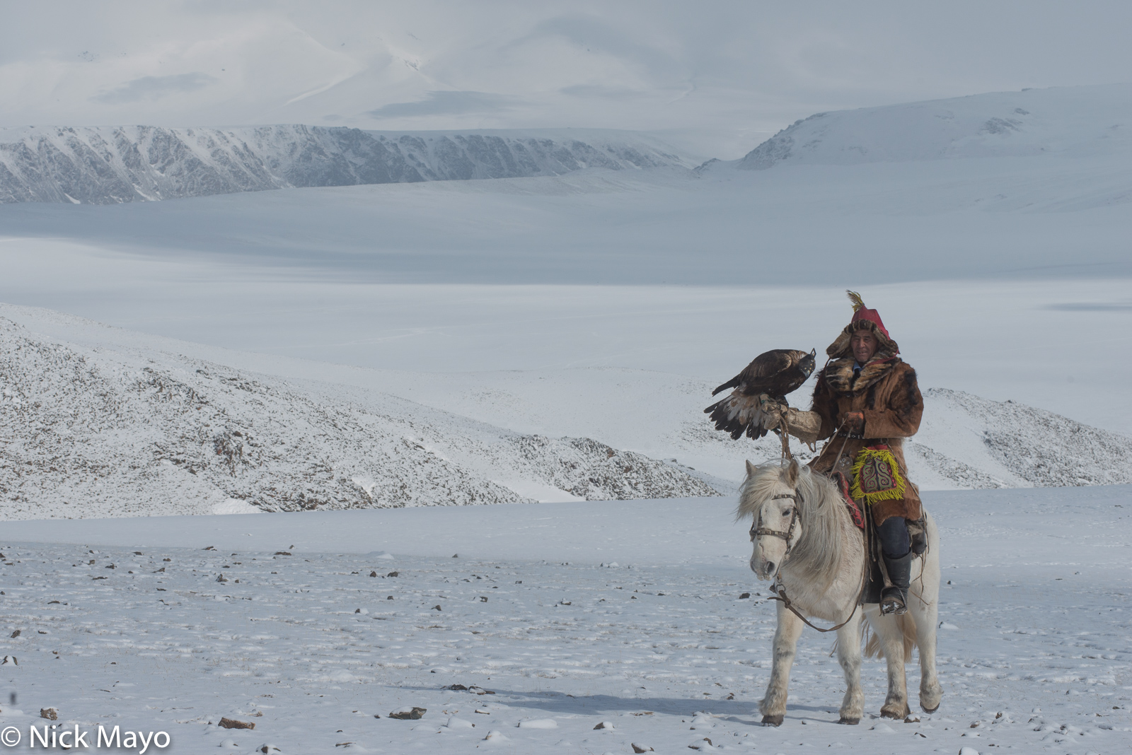 A Kazakh eagle hunter on horseback high in the Altai mountains in Ulaakhus sum.