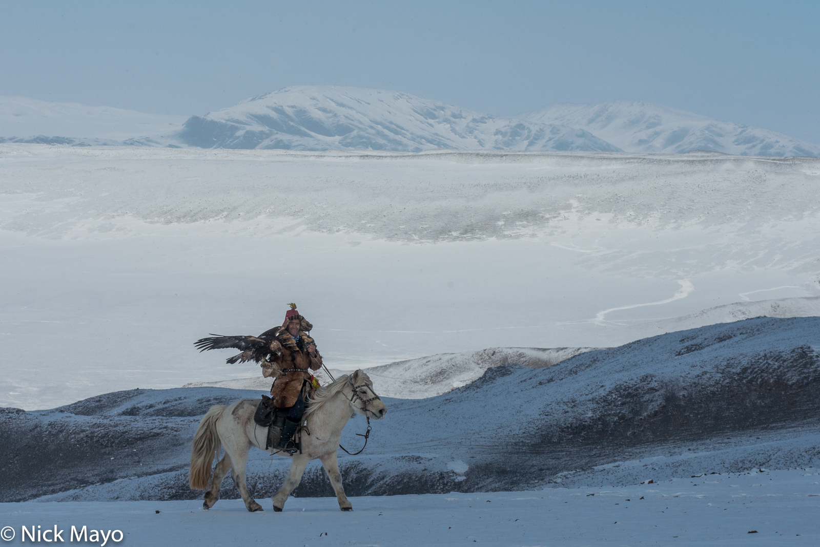 A Kazakh eagle hunter on horseback in the Altai mountains of Ulaakhus sum.