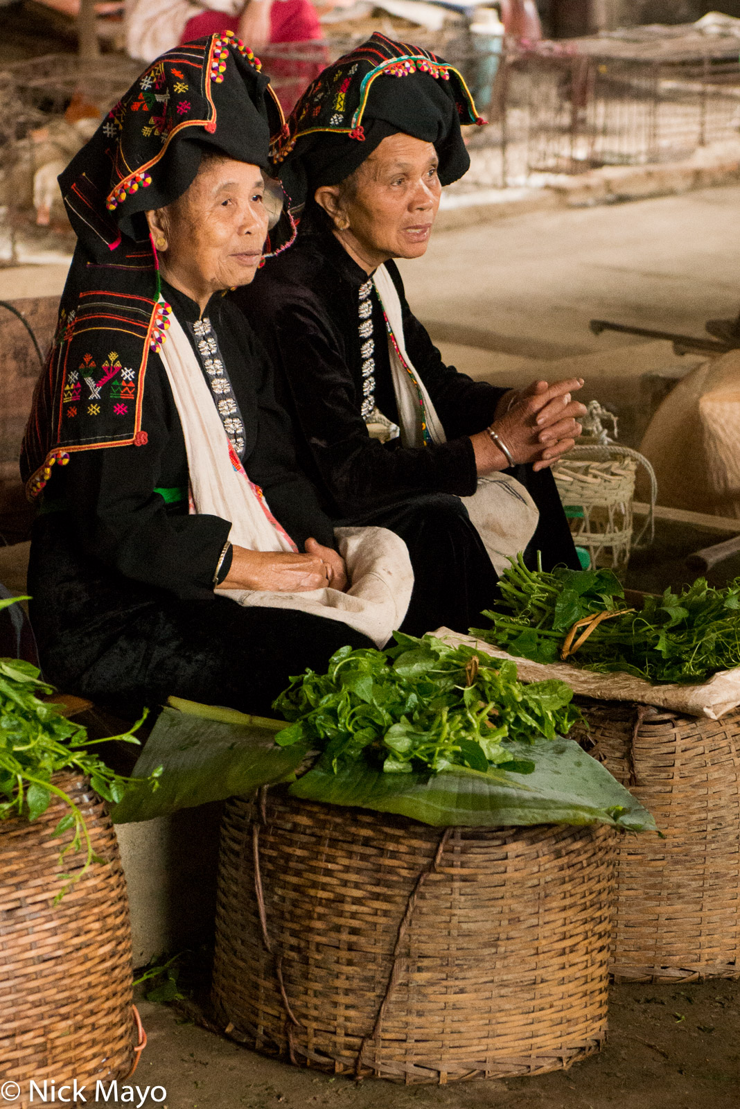 Two Black Thai (Dai) women selling vegetables at Thuan Chau market.