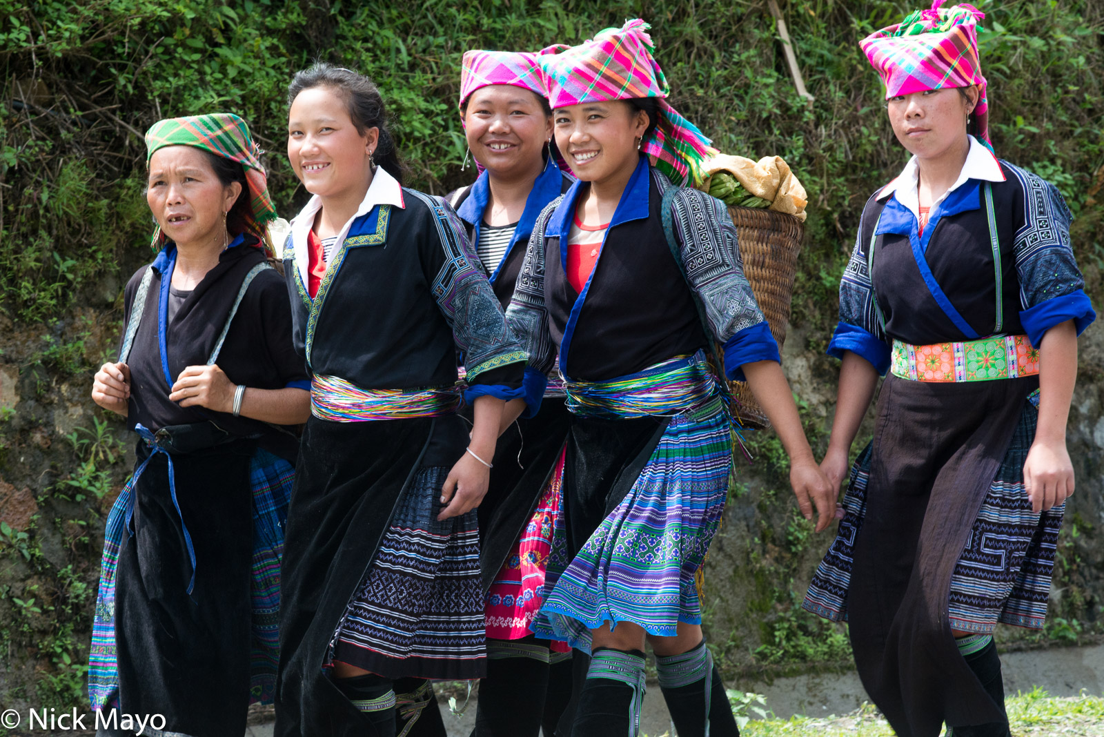 Five Blue Hmong women, one carrying a backstrap basket, at Khau Pha.
