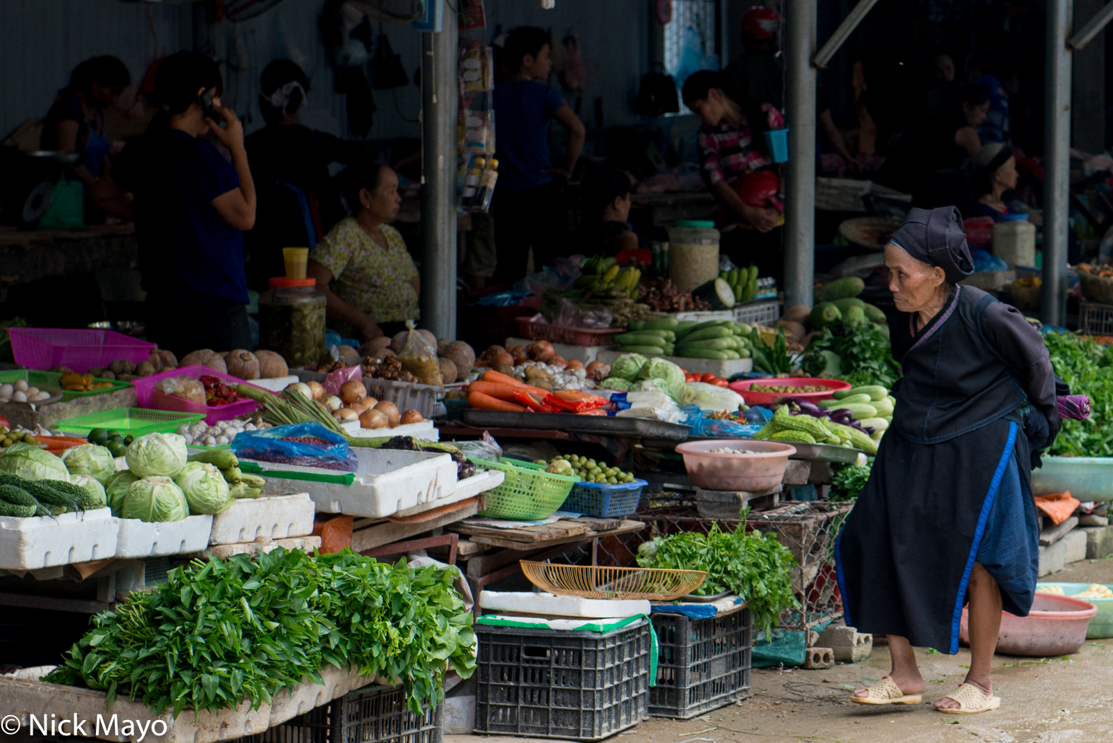 An older Nung (Zhuang) woman checking out the vegetable stands at Su Phi market.