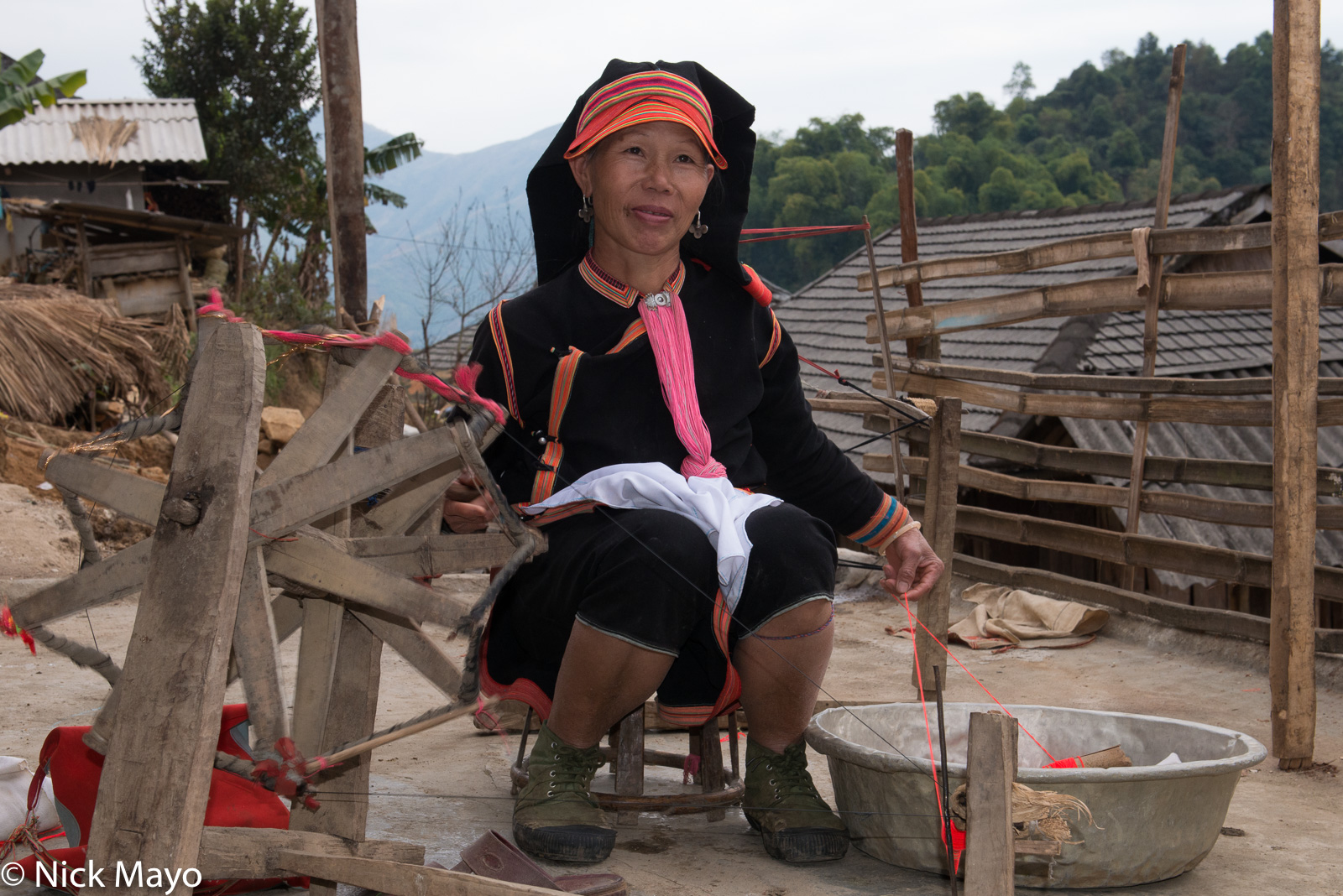 A woman spinning thread on a hand operated spindle in the Black Dao village of Pocha.