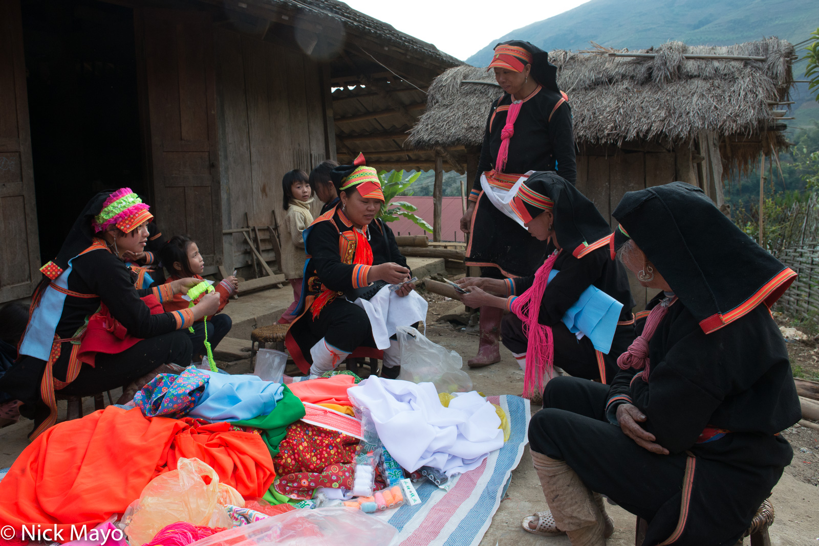 A woman paying for cloth in the Black Dao village of Pocha.