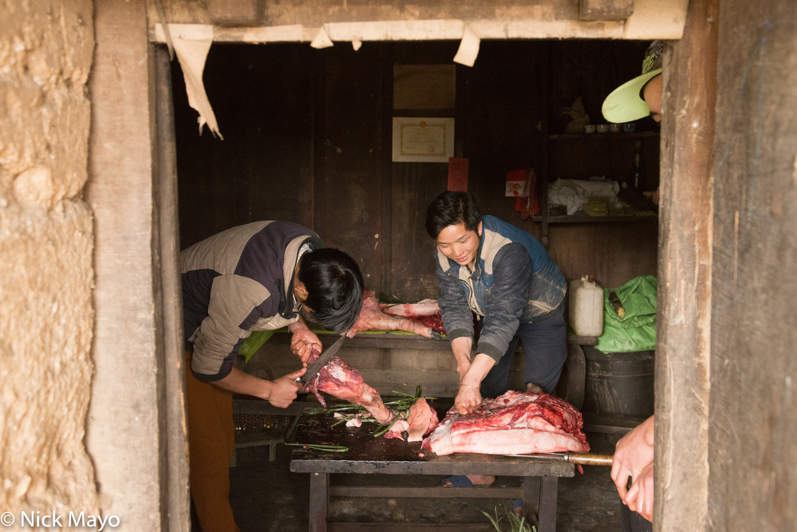 Si Lo Lau Dao men chopping up the meat of a pig for New Year meals.