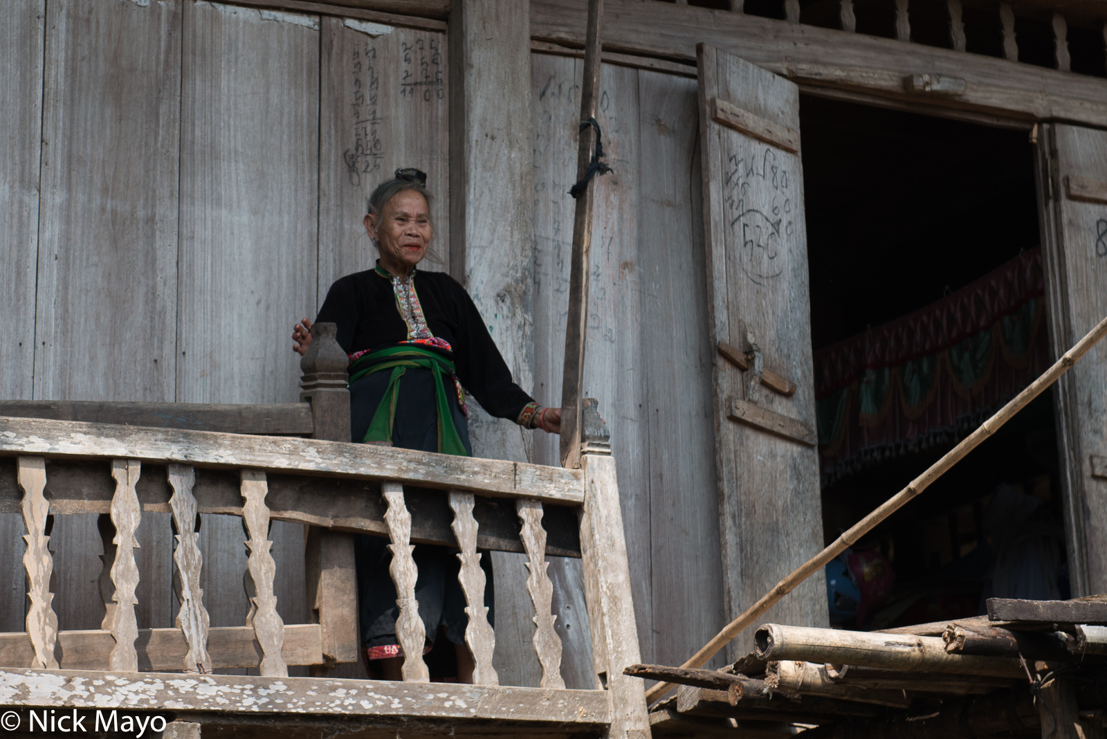 A Thai (Dai) woman on the balcony of her house in the Nam Ma valley.