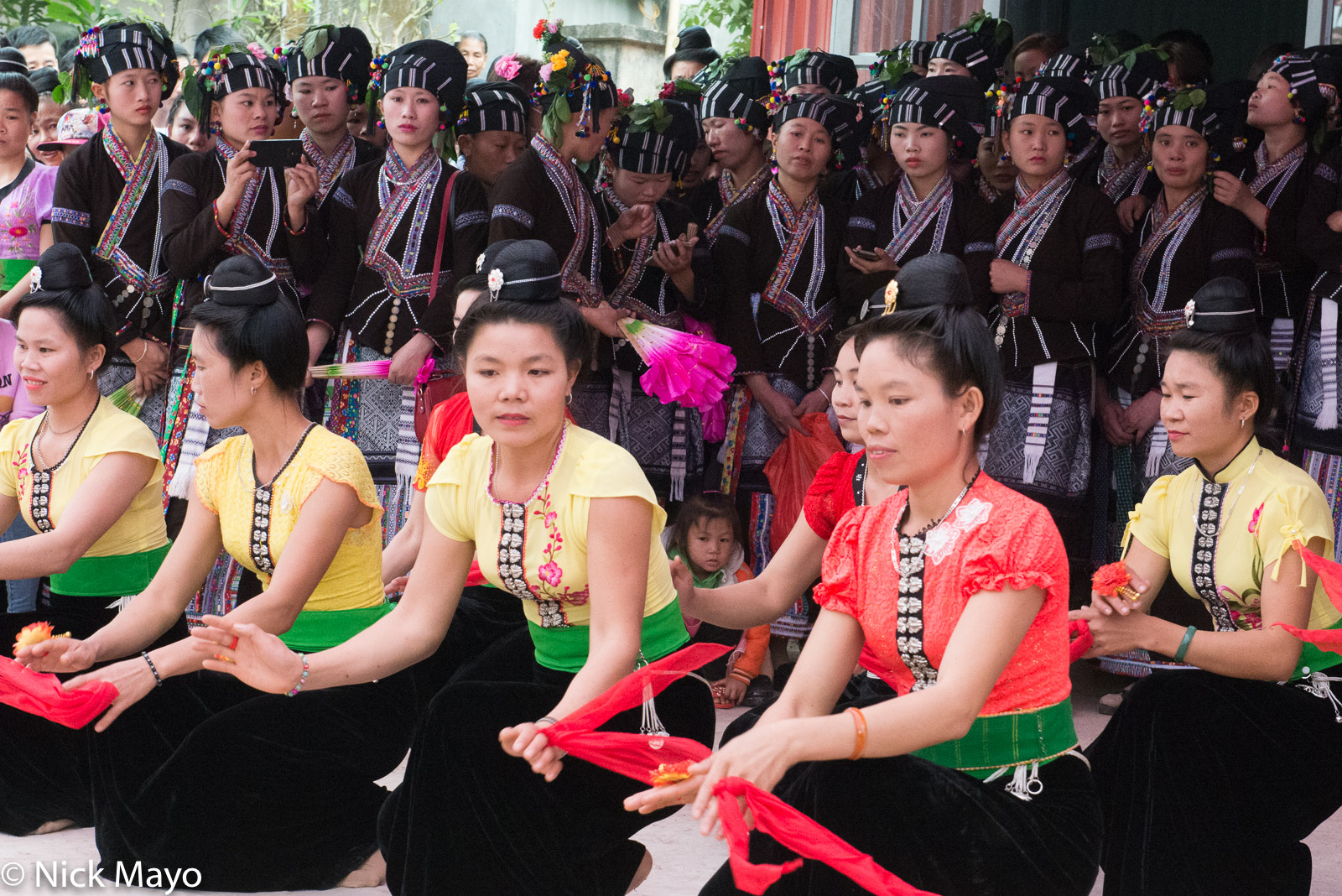 Lu women watching Thai (Dai) women dance at a New Year festival in the Nam Ma valley.