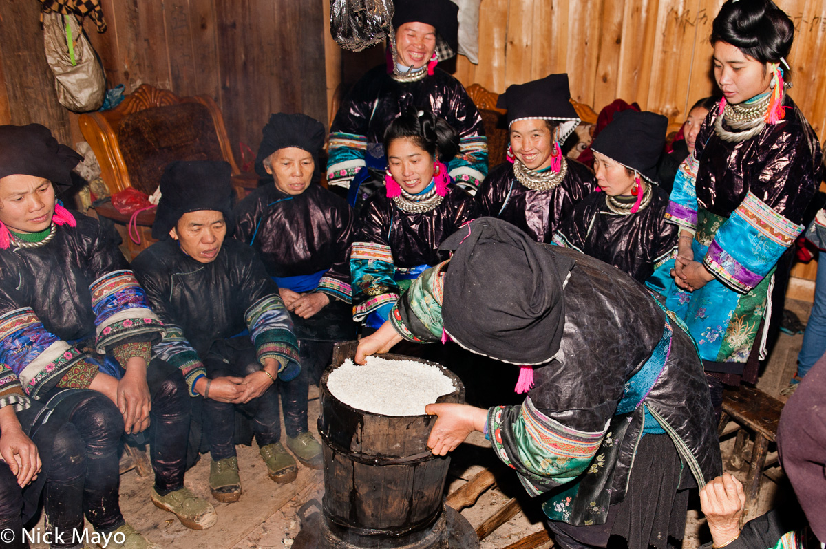 Women from Miao Gu village cooking rice at a baby shower lunch.