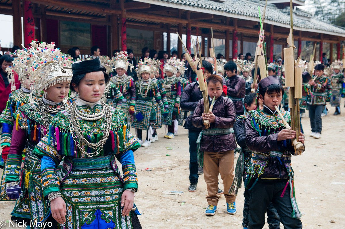 Miao girls circling with the lusheng pipers at a village festival in Mei De.