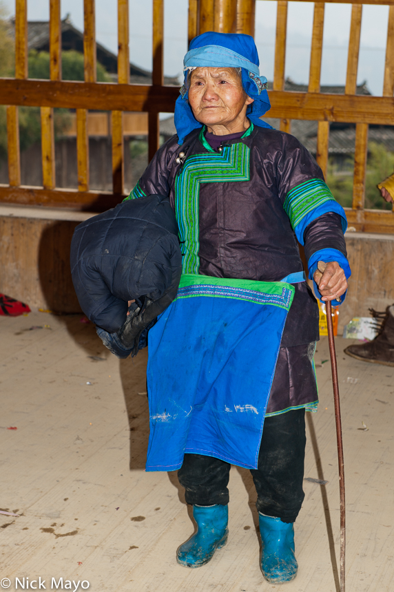 An older Miao woman in traditional blue hat and apron at a village festival in Mei De.