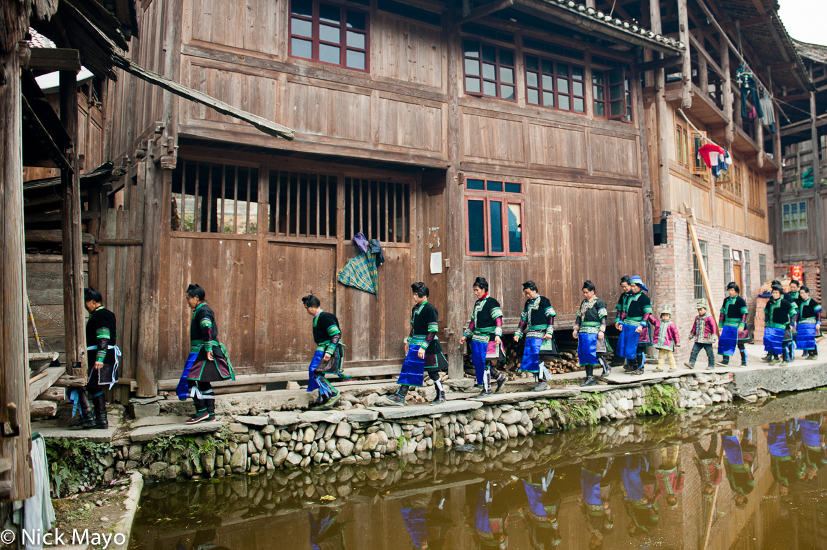 Traditionally dressed married women in a wedding column in the village of Shao Dong.