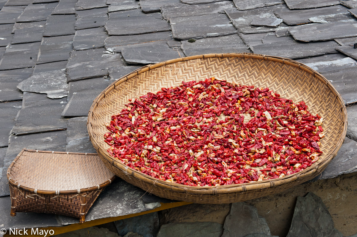 A basket of chillies drying on a roof In the upper Nujiang village of Qiulatong.