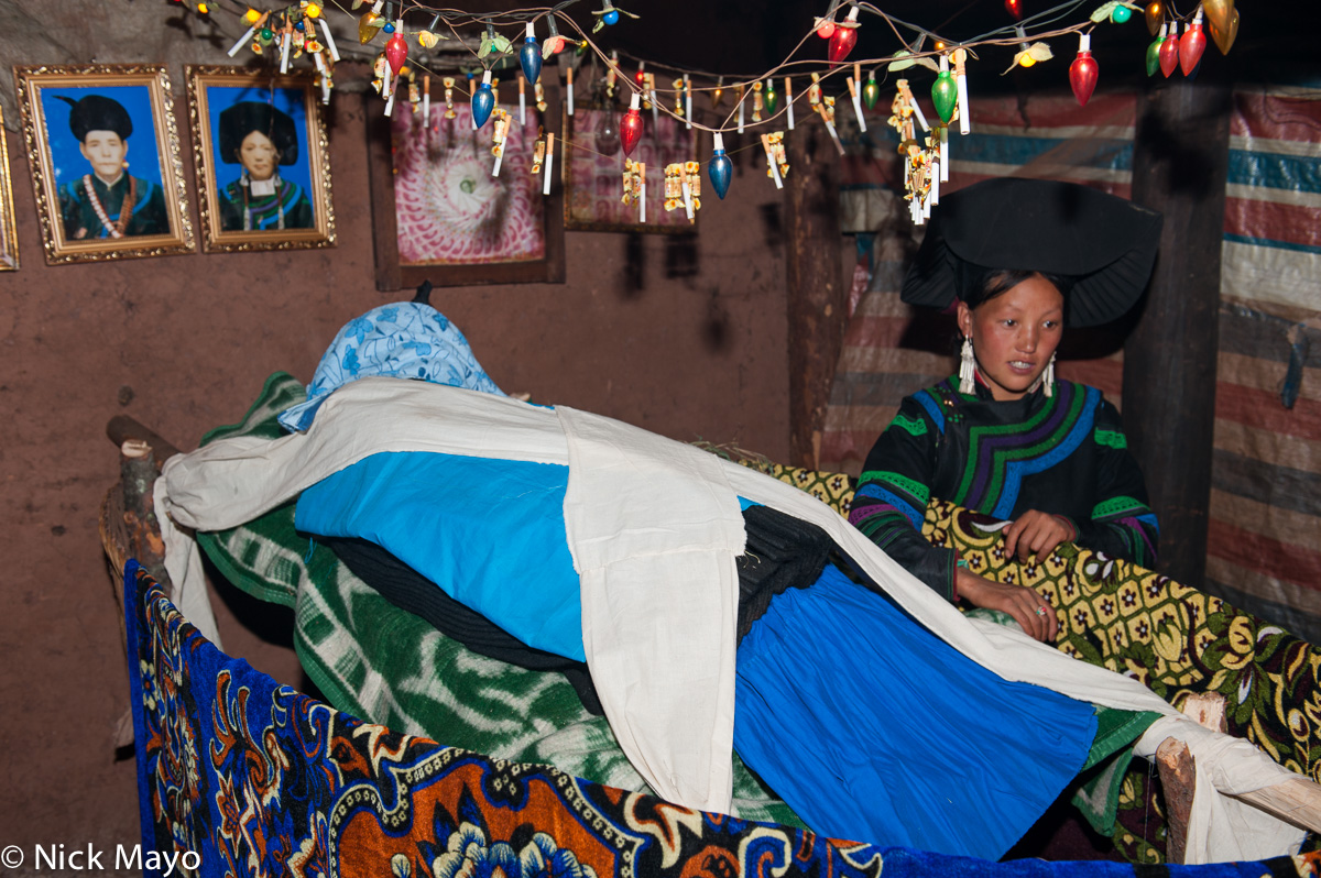 The deceased's granddaughter attending his body at a funeral at Mi Shi Qing Mo in Daliangshan.