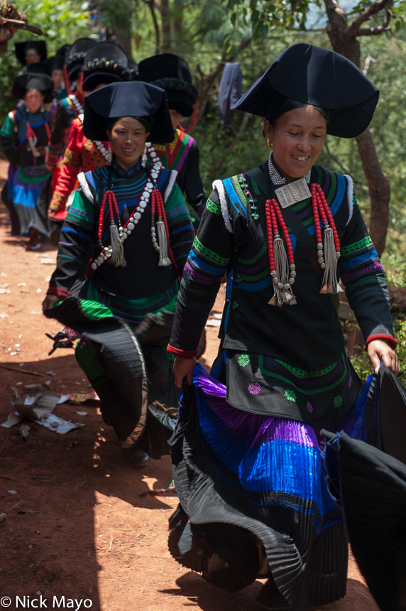 A female greeter leading a column of women to a Yi funeral at Mi Shi Qing Mo in Daliangshan.