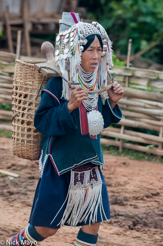 An Akha (Hani) woman carrying her water containers in a backstrap basket to the spring in the village of Hoi Yang II.