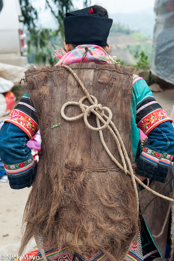 A Yi woman wearing a bark backpiece at Majie market.