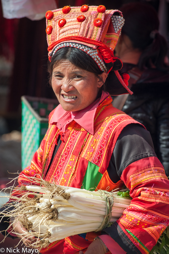 A Yi woman from the Xibeile area with a purchase of vegetables at Mengzi market.