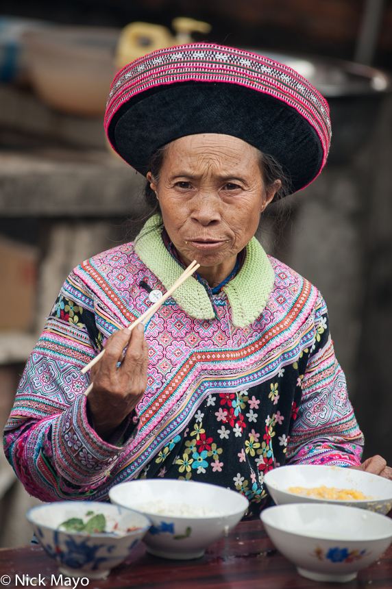 A Miao woman lunching in Baihe.