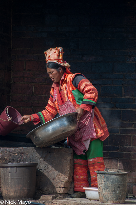 A Yi woman in the village of Tue Moh Di dressed in traditional clothes and hat.