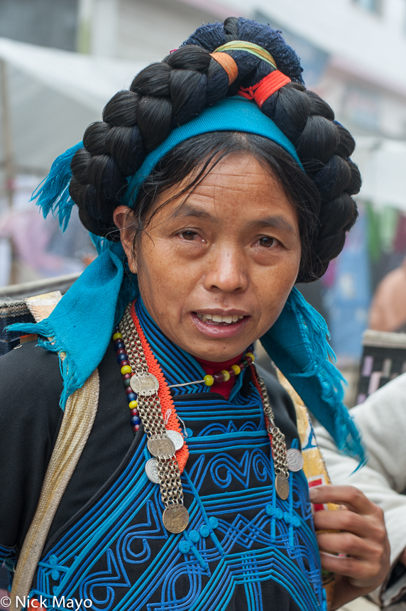 A Hani woman from the Maandi area wearing a hair piece of wool.