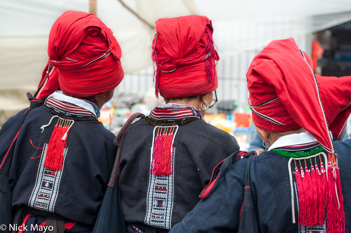 Red Yao women in Maandi wearing traditional hats and earrings.