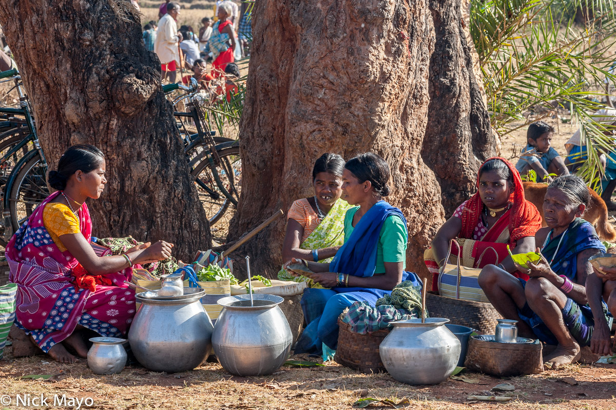 Maria women of the Gond ethnicity selling mahuli from containers at Madum market.