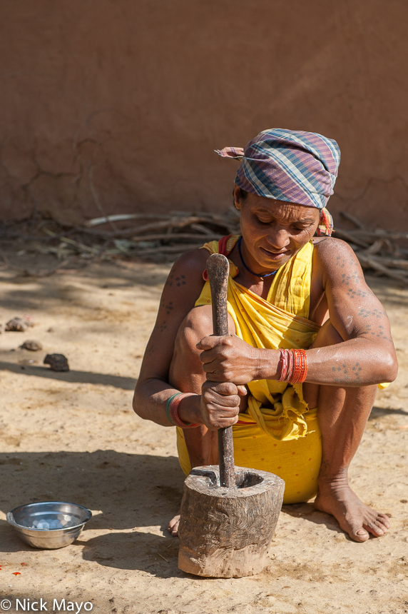 A traditionally tattooed Botra woman with mortar and pestle in the Gond village of Pajil. 