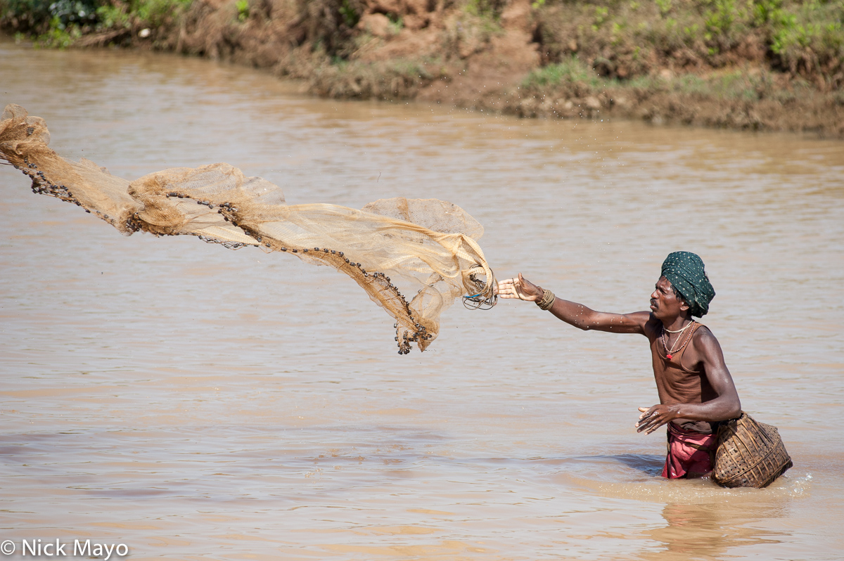 A turbanned fisherman, with basket and net, fishing near Jeypore.