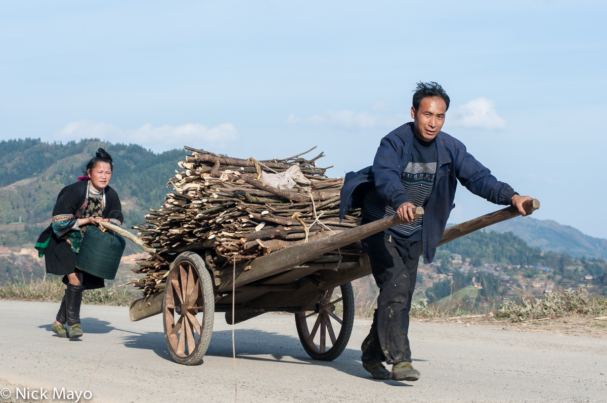 A Miao couple from Yu Min bringing firewood home on a cart.