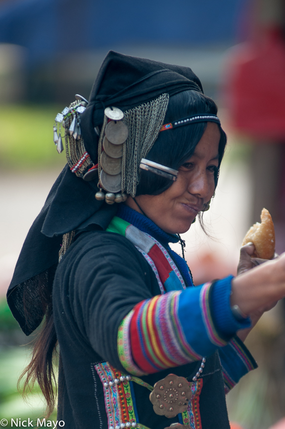 An Akha Pixor (Hani) woman at Boun Yo in her traditional clothes and hat.