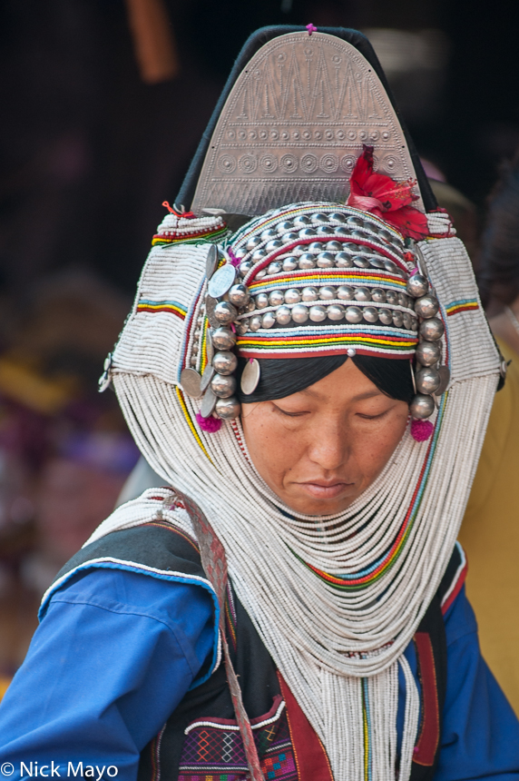 An Akha (Hani) women in Kengtung market wearing a full headdress.