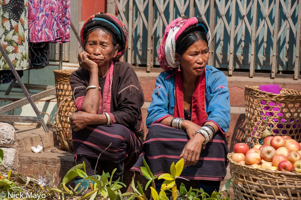 Palaung women, wearing traditional turbans, bracelets and earrings, selling produce at Lashio market.