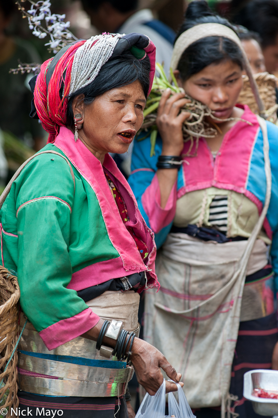 A Palaung woman, wearing a traditional turban, waist hoops and bracelets, at Lashio market.