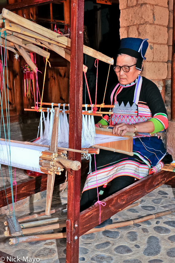 A Hua Yao Dai woman from Mosha weaving on a frame loom.