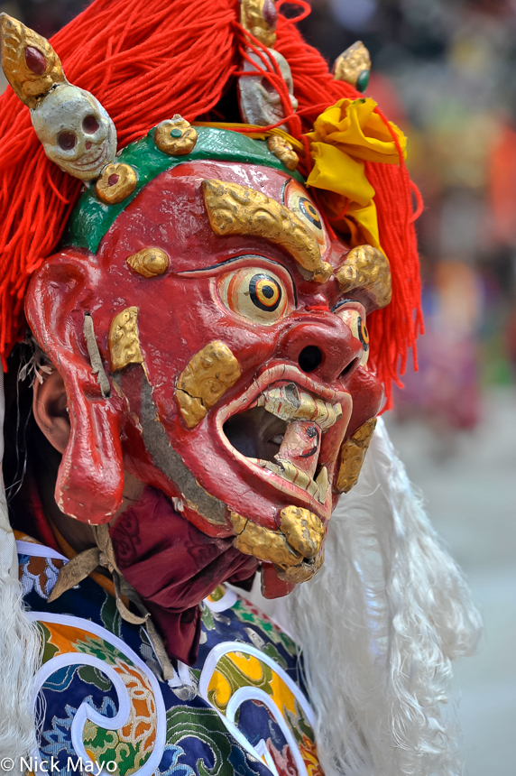 A Tibetan monk wearing a festival mask at Katok.