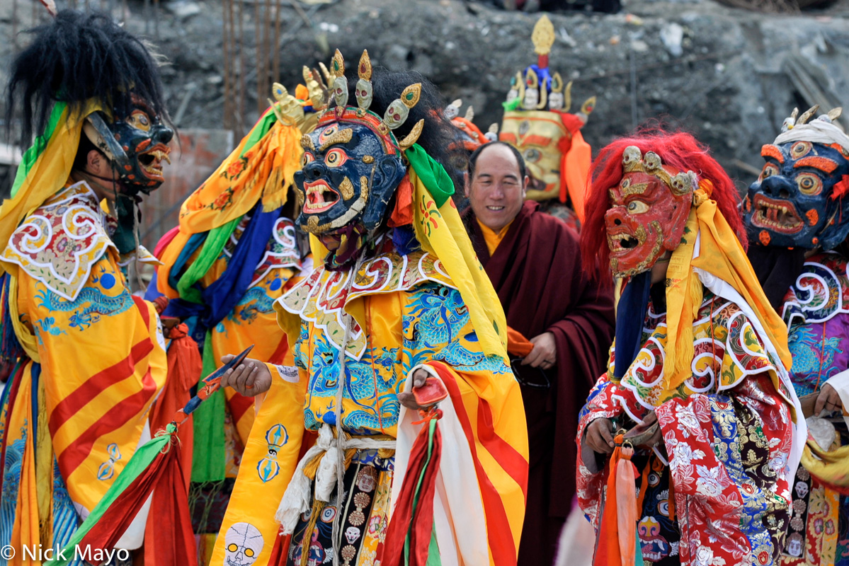 Four masked Tibetan monks waiting to dance at a festival at the Katok monastery.