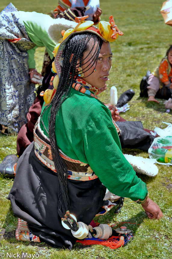 A Tibetan woman wearing an amber hair piece and traditional stone earrings at a festival in Sershul.