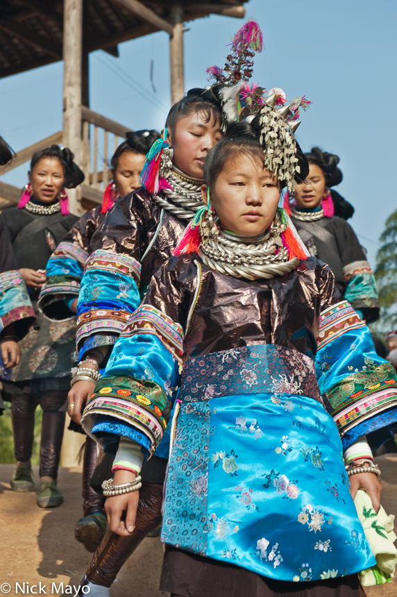 A Miao bride and bridesmaid on their way to a wedding in the village of Gui Lai.
