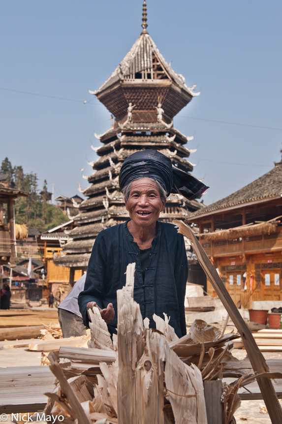 A turbanned Dong man in front of the drum tower in the village of Yintan.