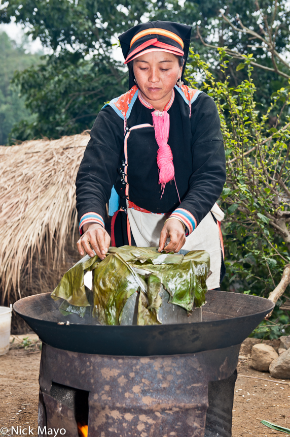 A Yao woman cooking rice on a wok for a wedding banquet in Hui Yang Lao Zai.