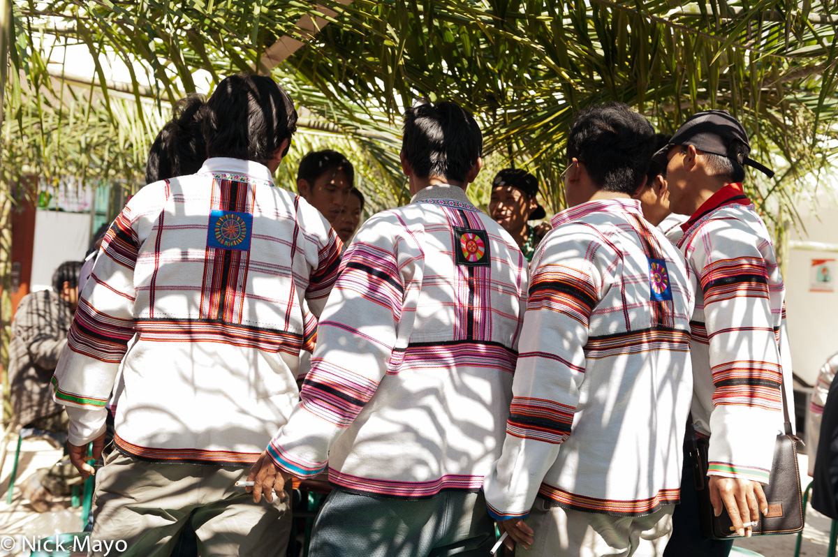 Traditionally dressed Jinuo men drinking a toast at a housewarming celebration in Lao Puxi.