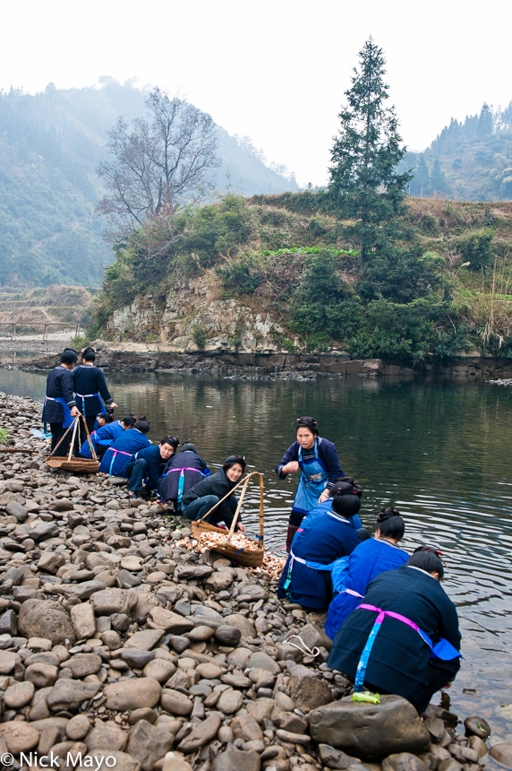 A group of Miao women by the river in Lan Hua Ling preparing vegetables for lunch.