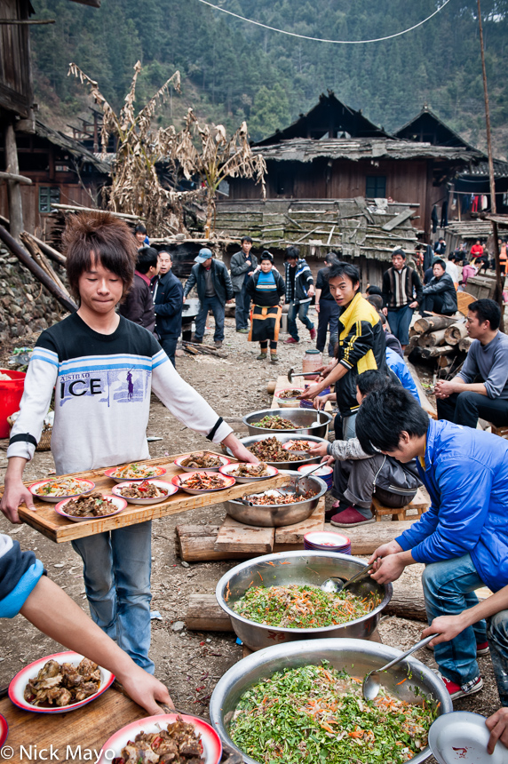 Miao youths serving vegetables at a wedding lunch in Cenzui.