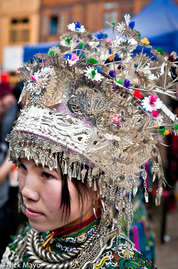 An unmarried girl wearing a crown headdress and silver necklace at a New Year festival in Yang Dong.