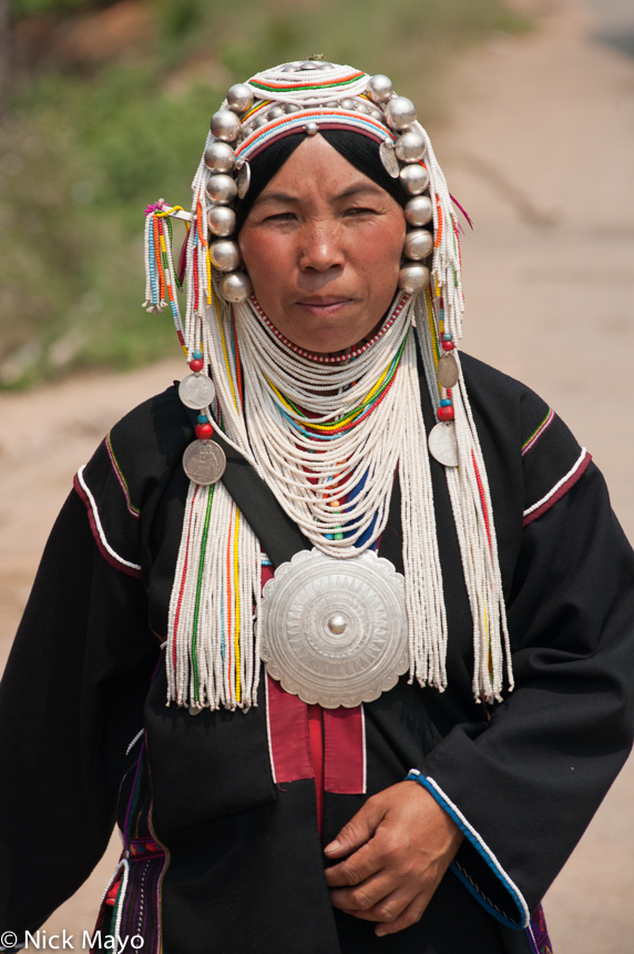 An Akha (Hani) woman from Hojin wearing a traditional breastpiece and headdress.