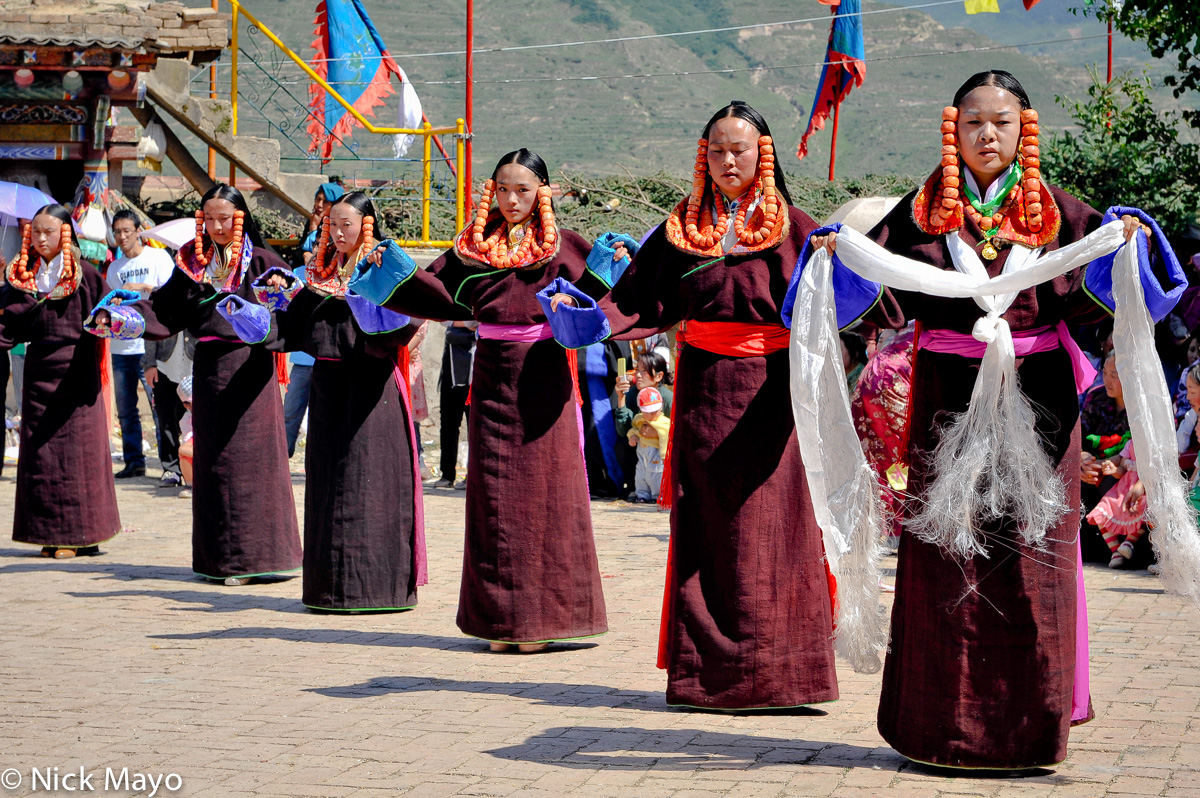 Tibetan women, one holding a kata, participating in a monastery festival in Rongpo Gyakhar. 