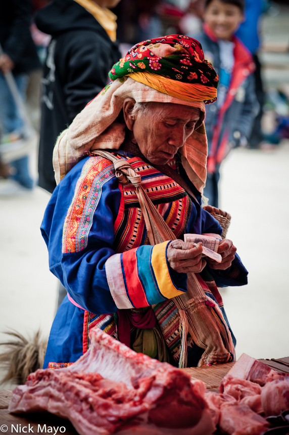 A Lahu woman shopping for meat at Nanmei market.